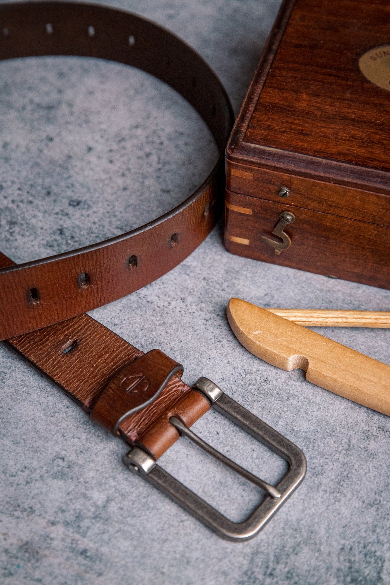 The Alarico belt in cognac milled leather, composed and at rest