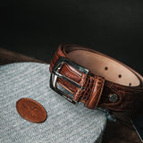 The embossed grain of the Alessandro dress belt in cognac.