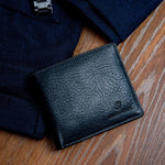 The milled Vachetta leather of the Alonzo bifold wallet in black.