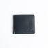 The Alonzo bifold wallet in black milled Vachetta leather, closed.