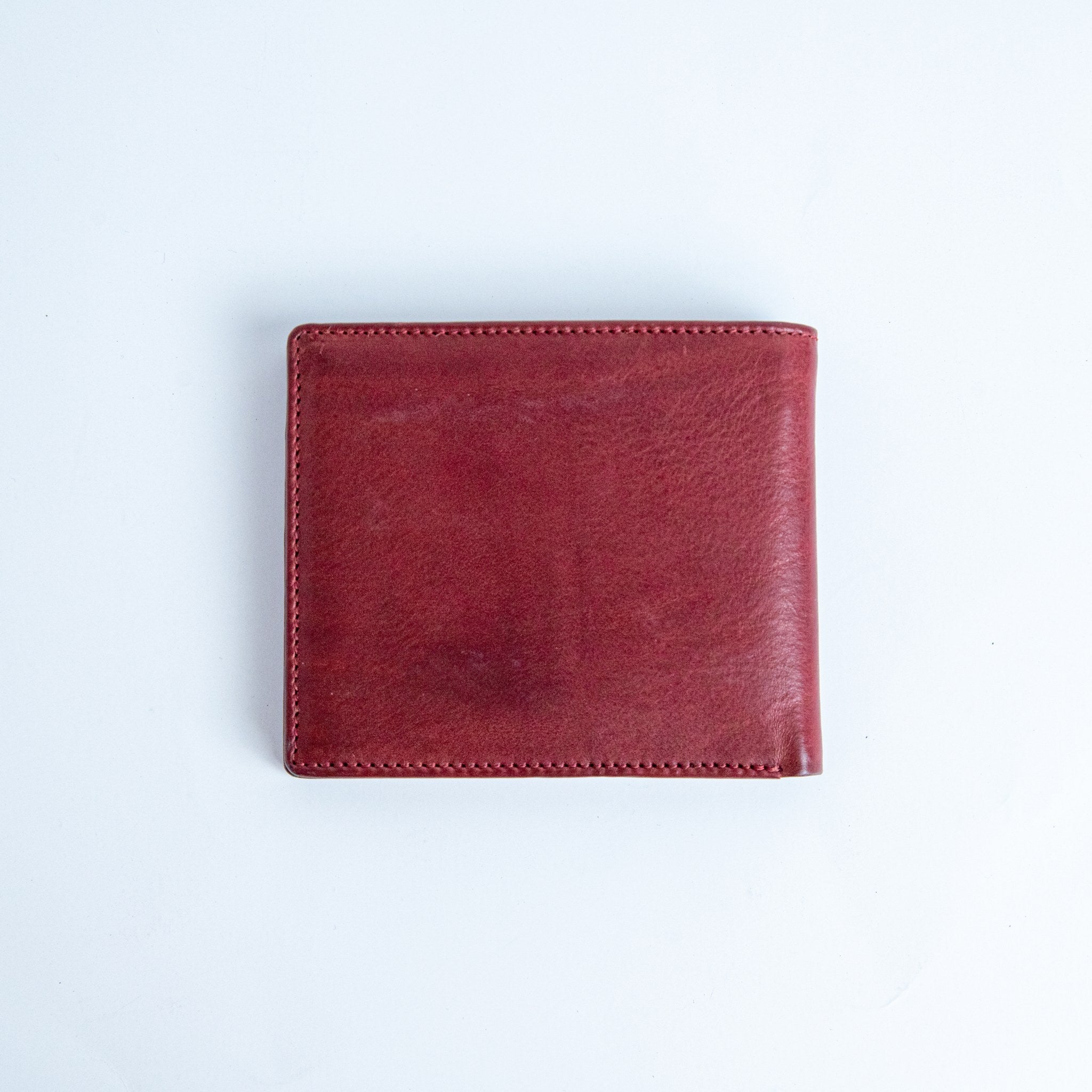 The back of the Alonzo bifold wallet in red milled Vachetta leather.