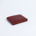 The Alonzo bifold wallet in red milled Vachetta leather.