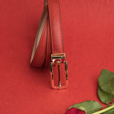 The natural Vachetta leather of the Anna dress belt in red.