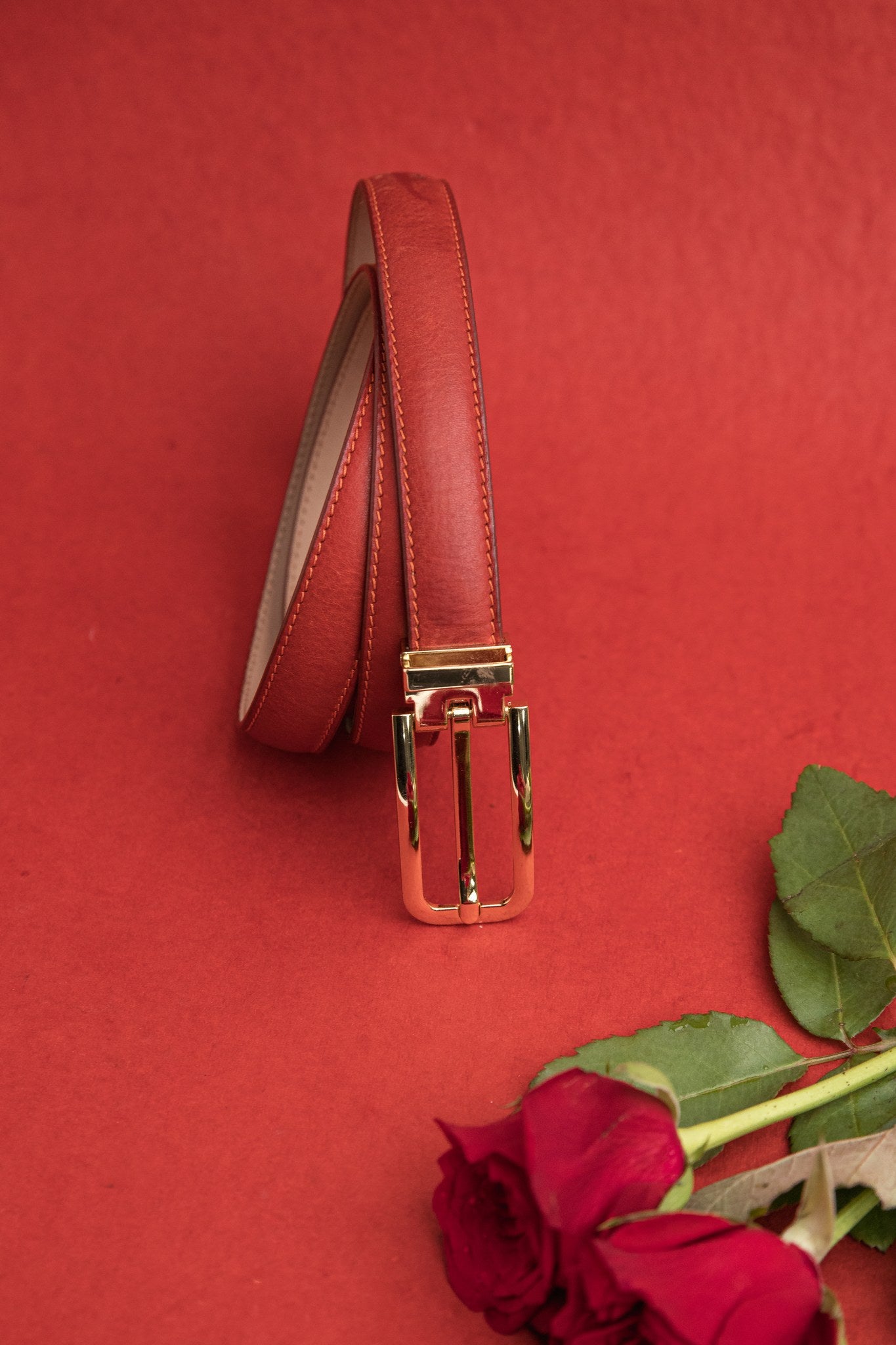 The natural Vachetta leather of the Anna dress belt in red.