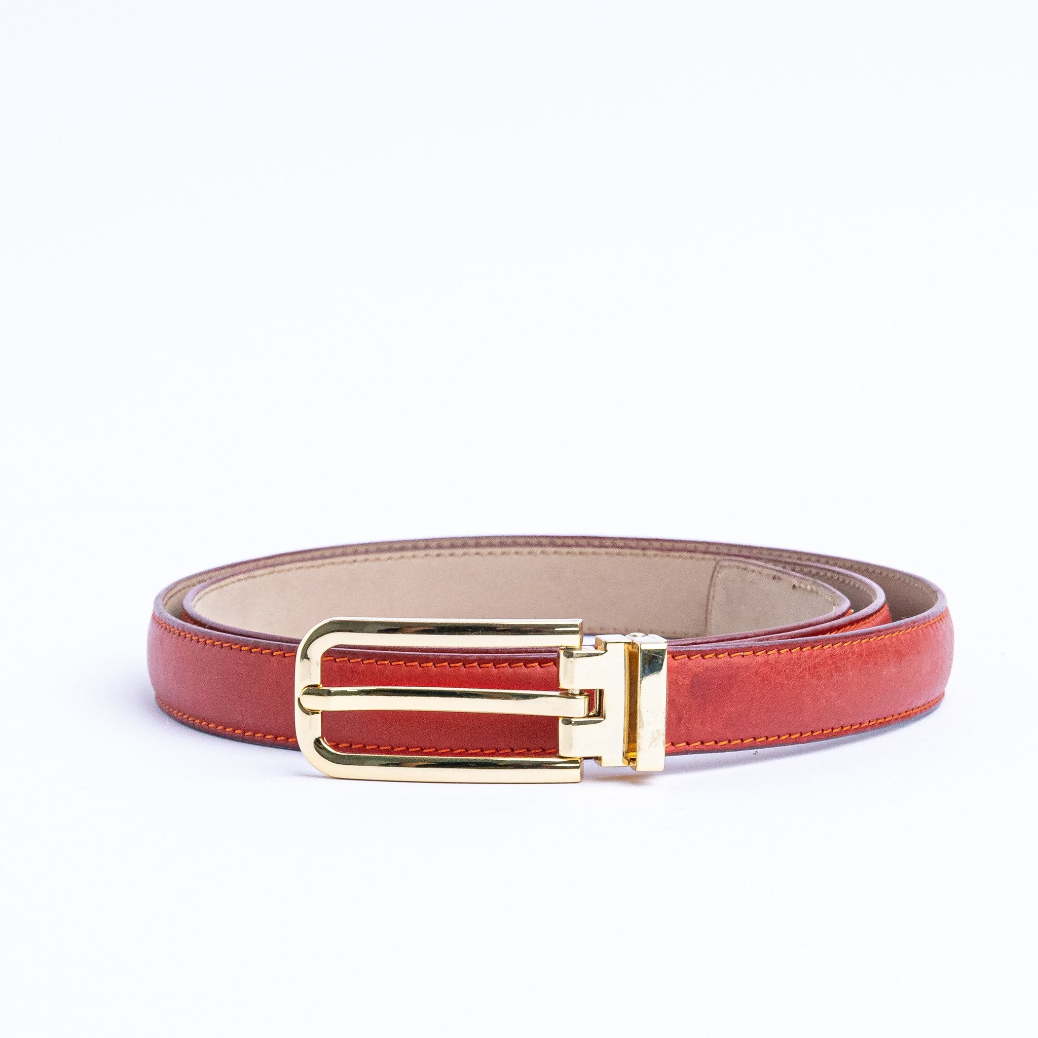 The gold buckle of the Anna Vachetta dress belt in red.