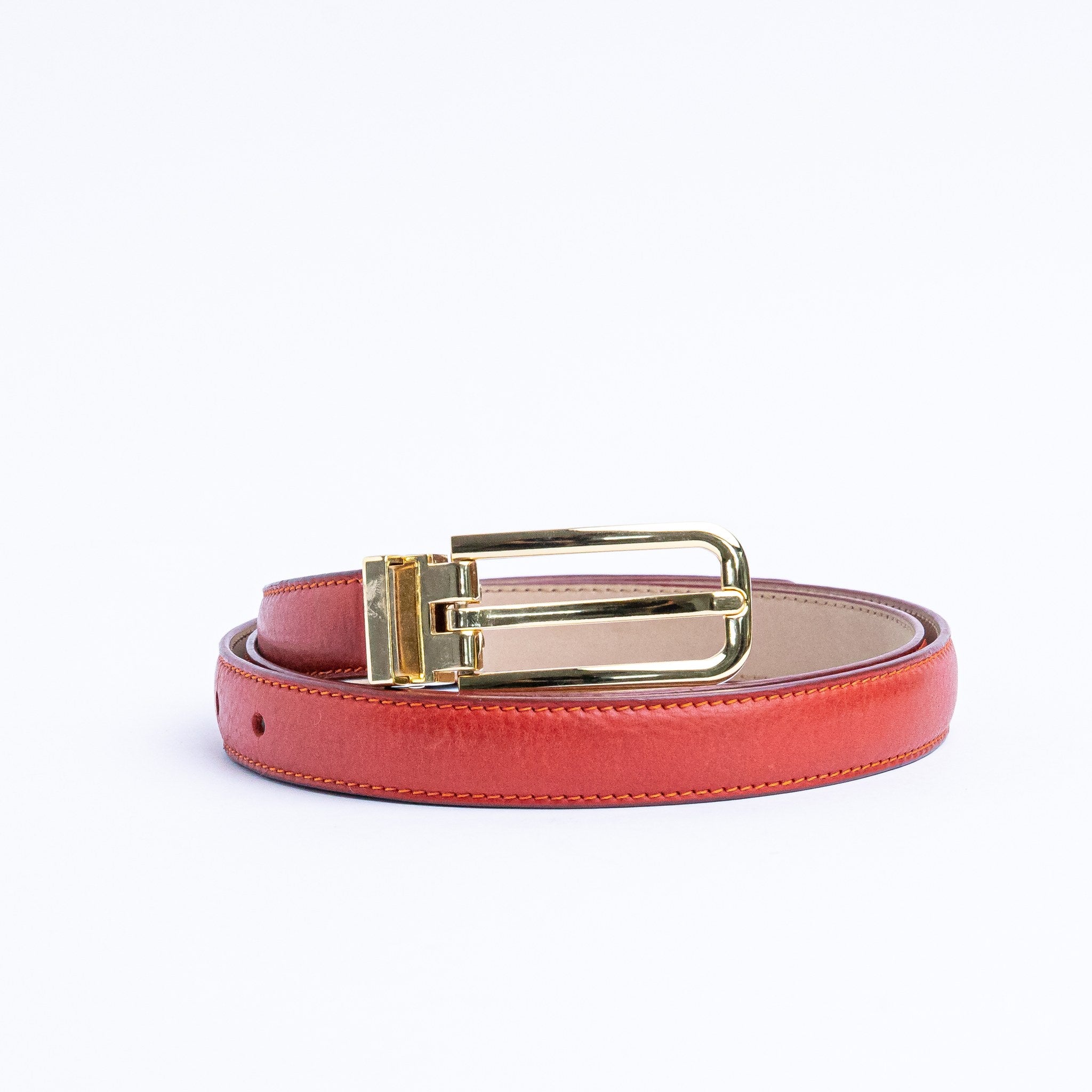 The Anna dress belt in red Italian Vachetta leather, coiled.