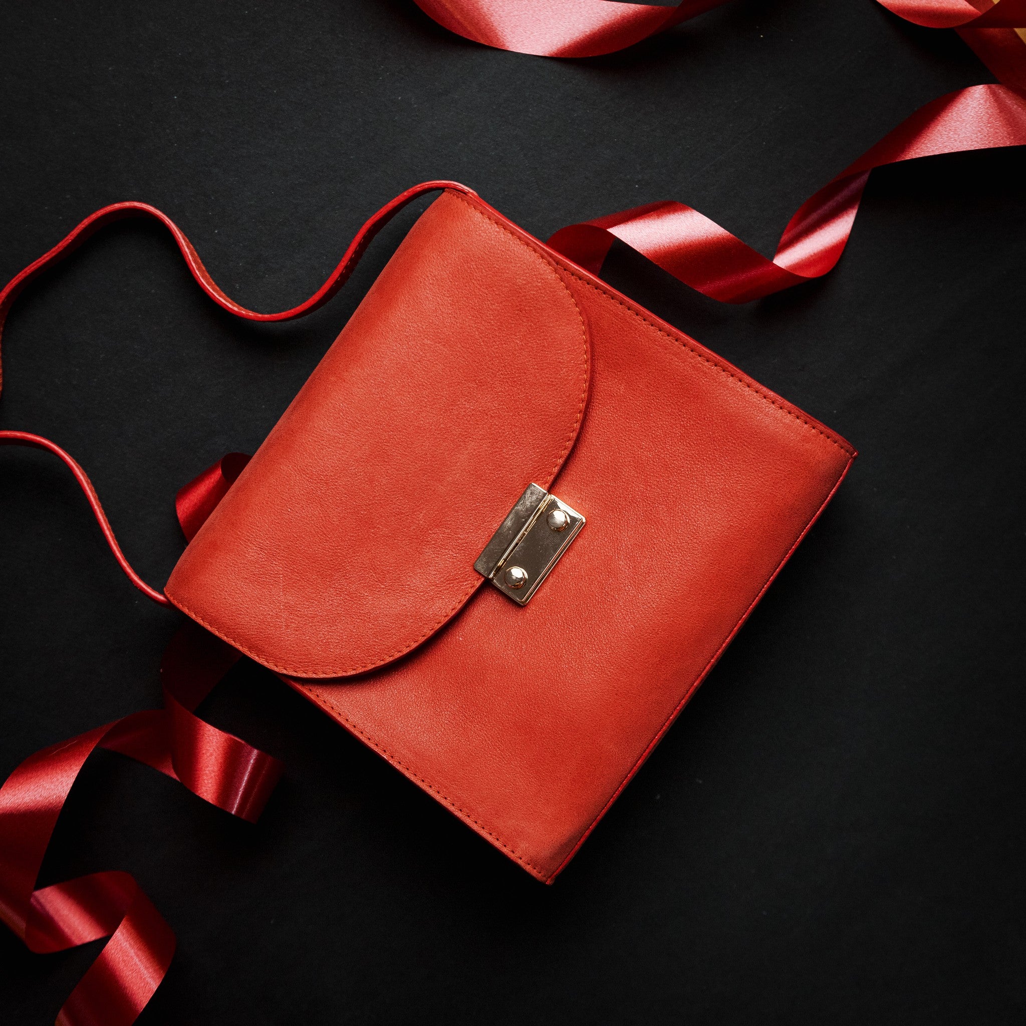 Ocean's Bloom orange peach leather handbag, carried.