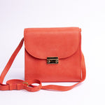 Close view of the milled leather and stitching on Ocean's Bloom, in orange peach.