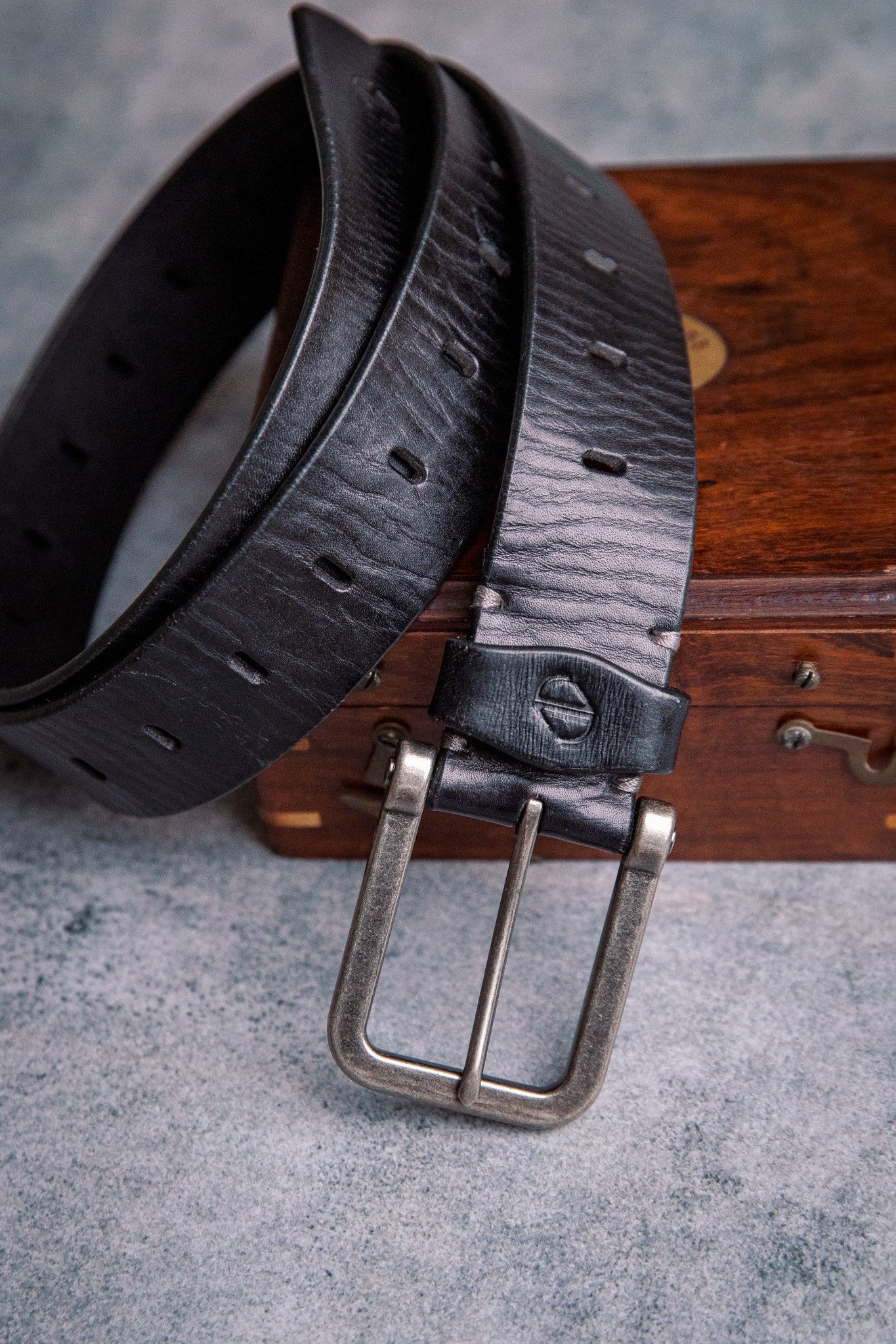 The Alarico belt in black milled leather, composed and at rest