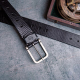The Alarico belt in black milled leather shown at full length, with dull nickel buckle