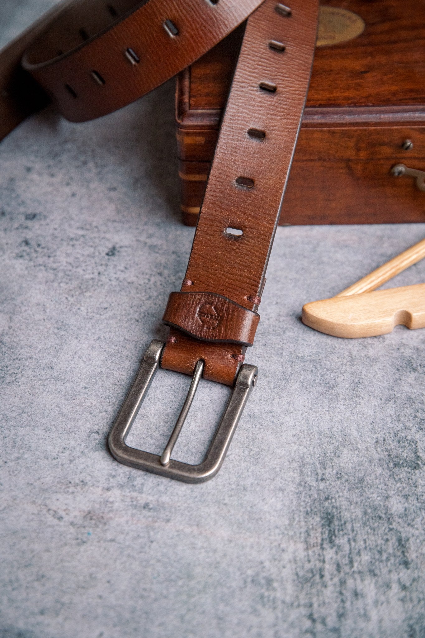 Close view of the milled leather grain of the Alarico belt in cognac