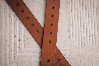 The Alarico belt in tan milled leather shown at full length, with dull nickel buckle
