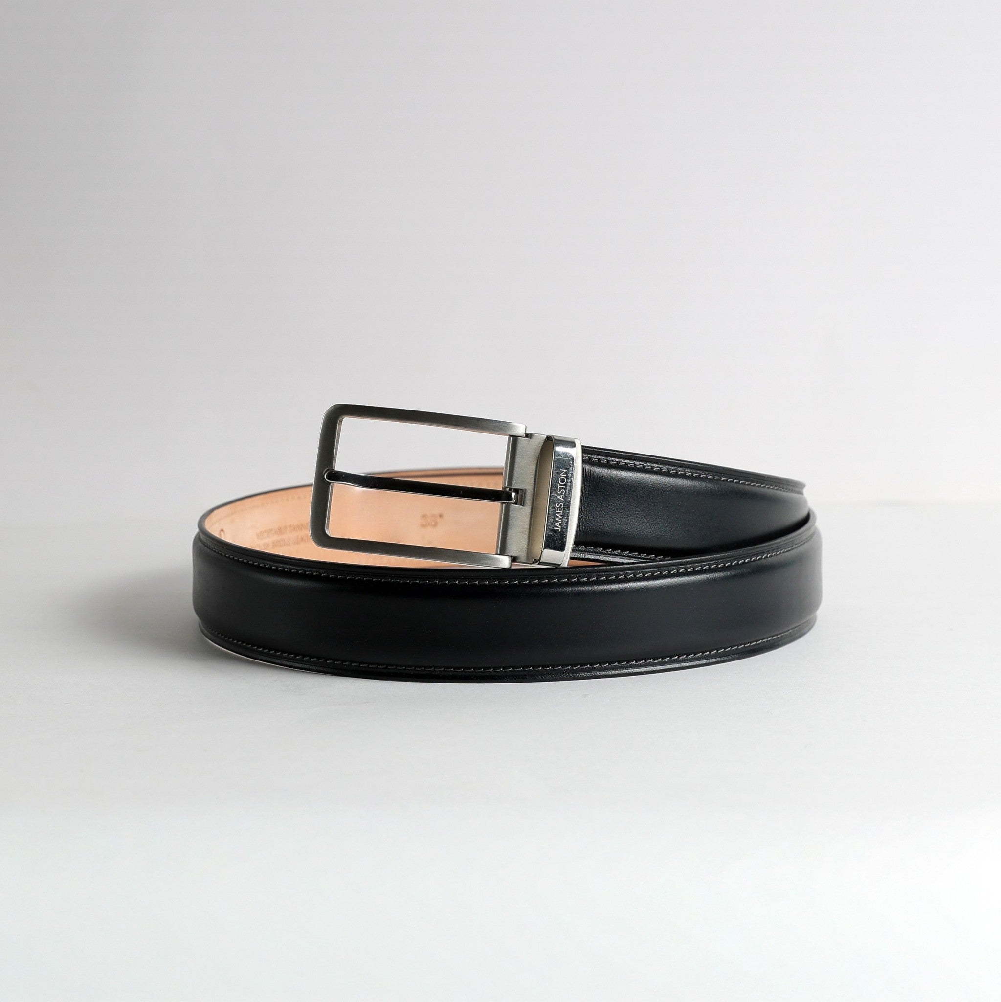 Close profile of the nickel buckle and grey tone on tone stitching on The Cesare Black Bridle belt