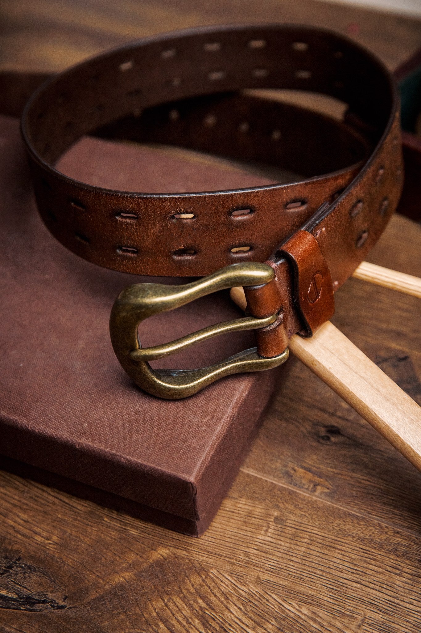 The Damian belt in cognac milled leather, composed and at rest