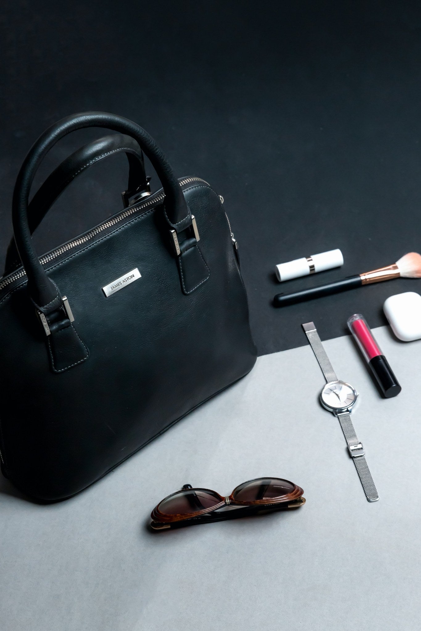 The Executive Handbag in black, carried close.