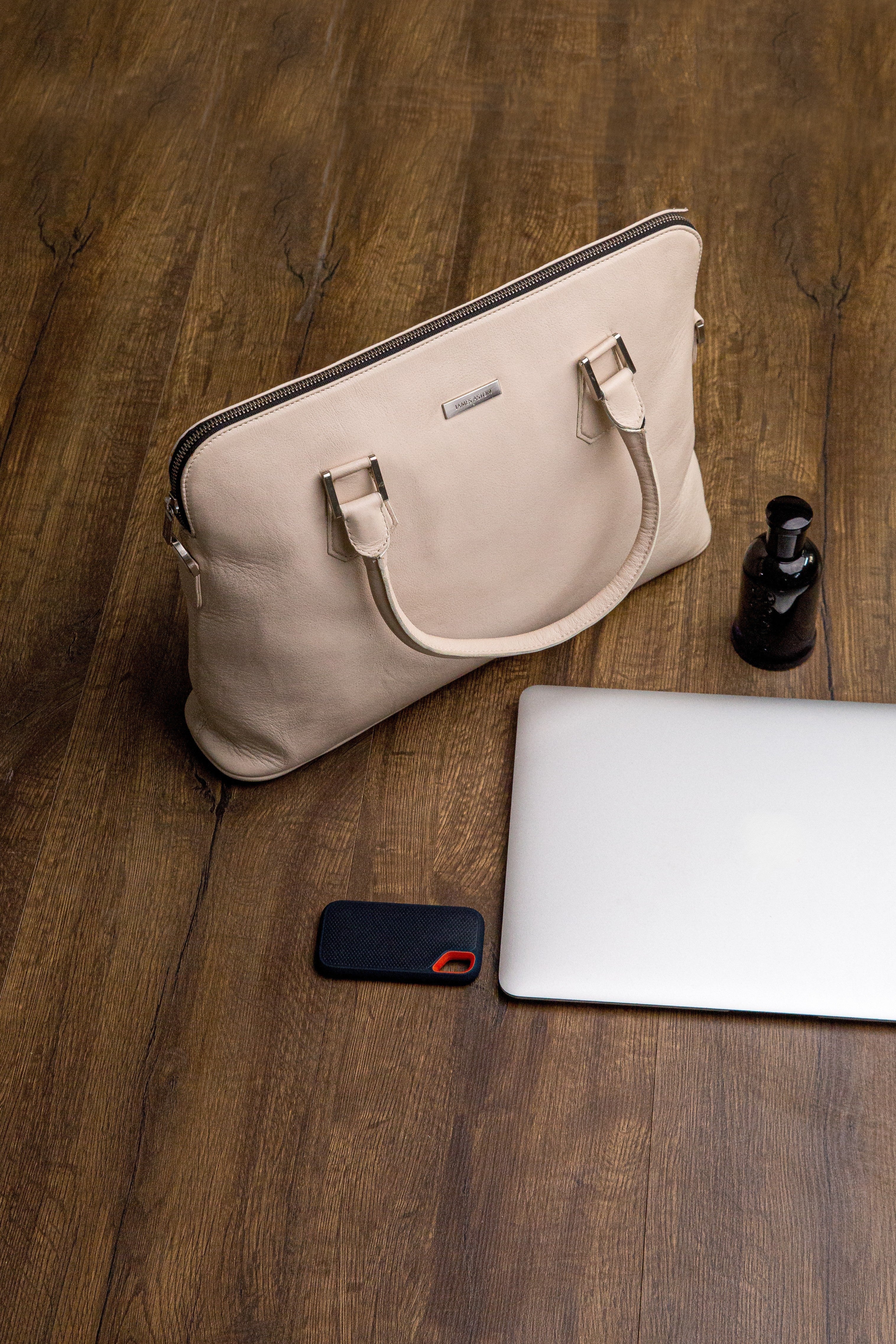 The Executive Laptop Bag in off-white, carried for the day.