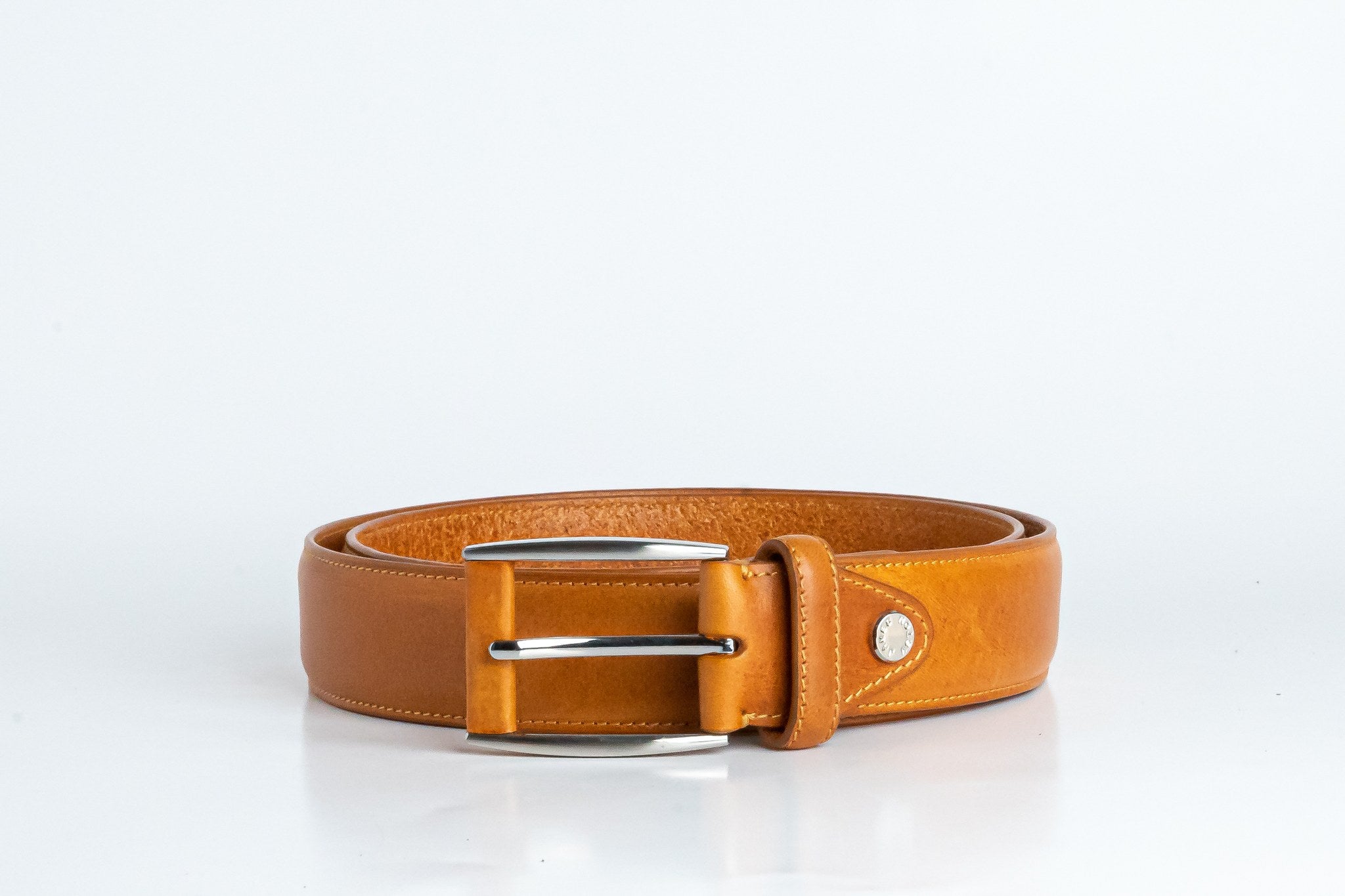 Close view of the brushed nickel buckle and solid brass screw on the Federico belt in tan