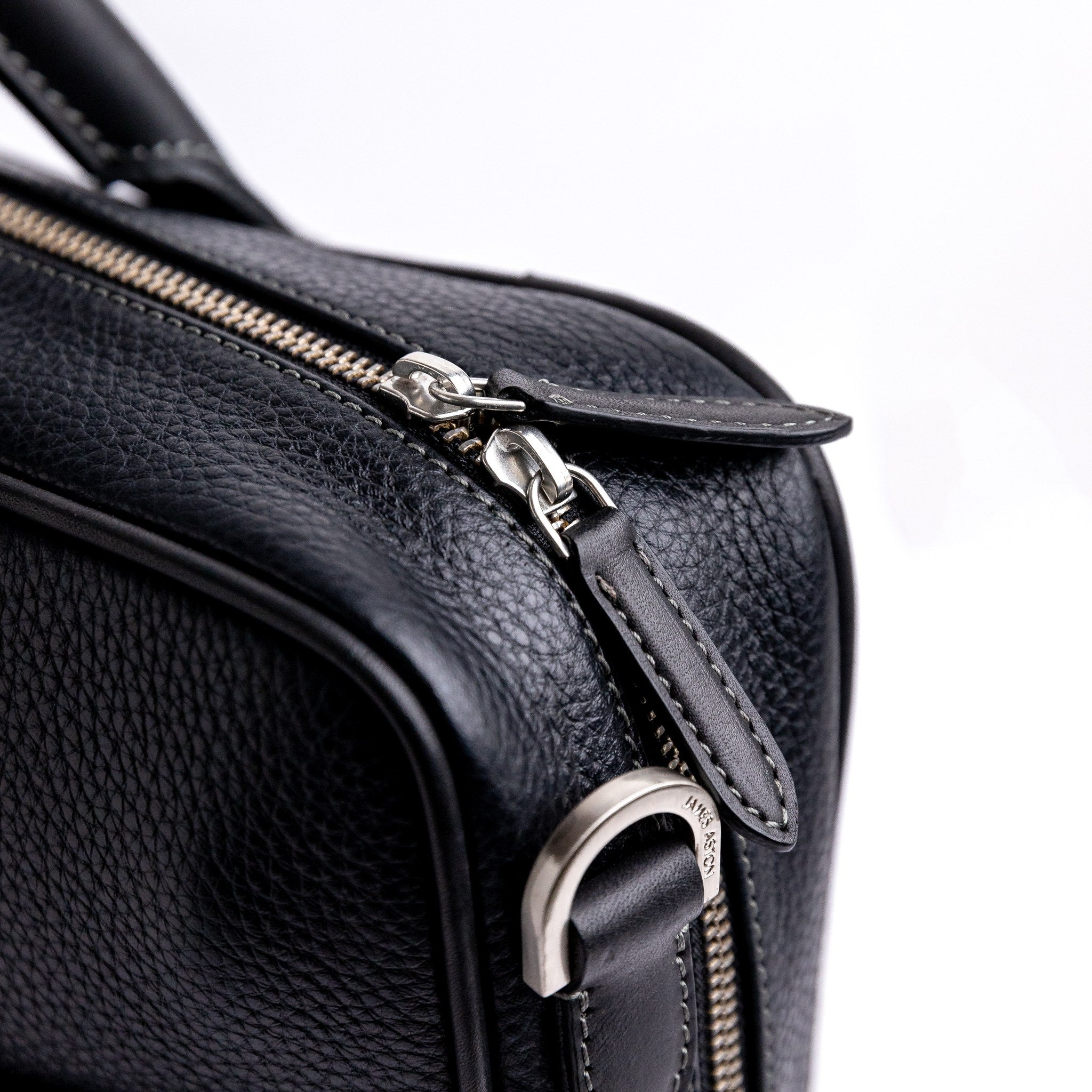 Brushed nickel zip and metalware on The Mentor black leather laptop bag.