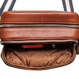 Brushed nickel D-rings, snap hooks and adjuster on The Minimal Sling cognac leather bag.