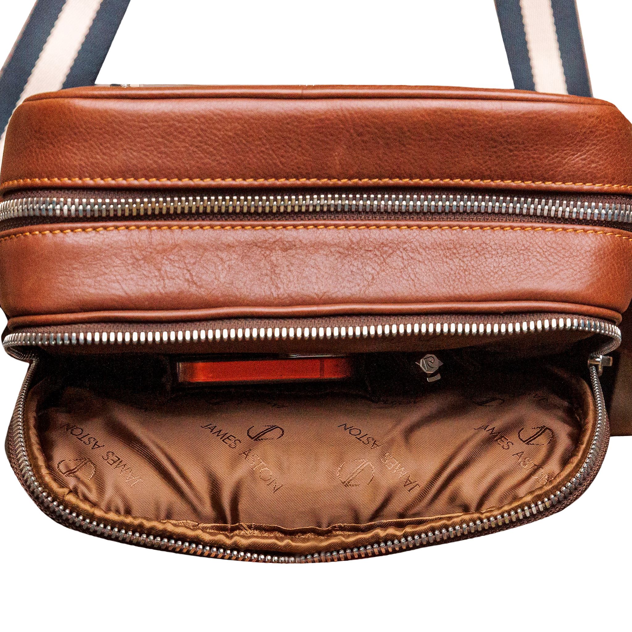 Brushed nickel D-rings, snap hooks and adjuster on The Minimal Sling cognac leather bag.