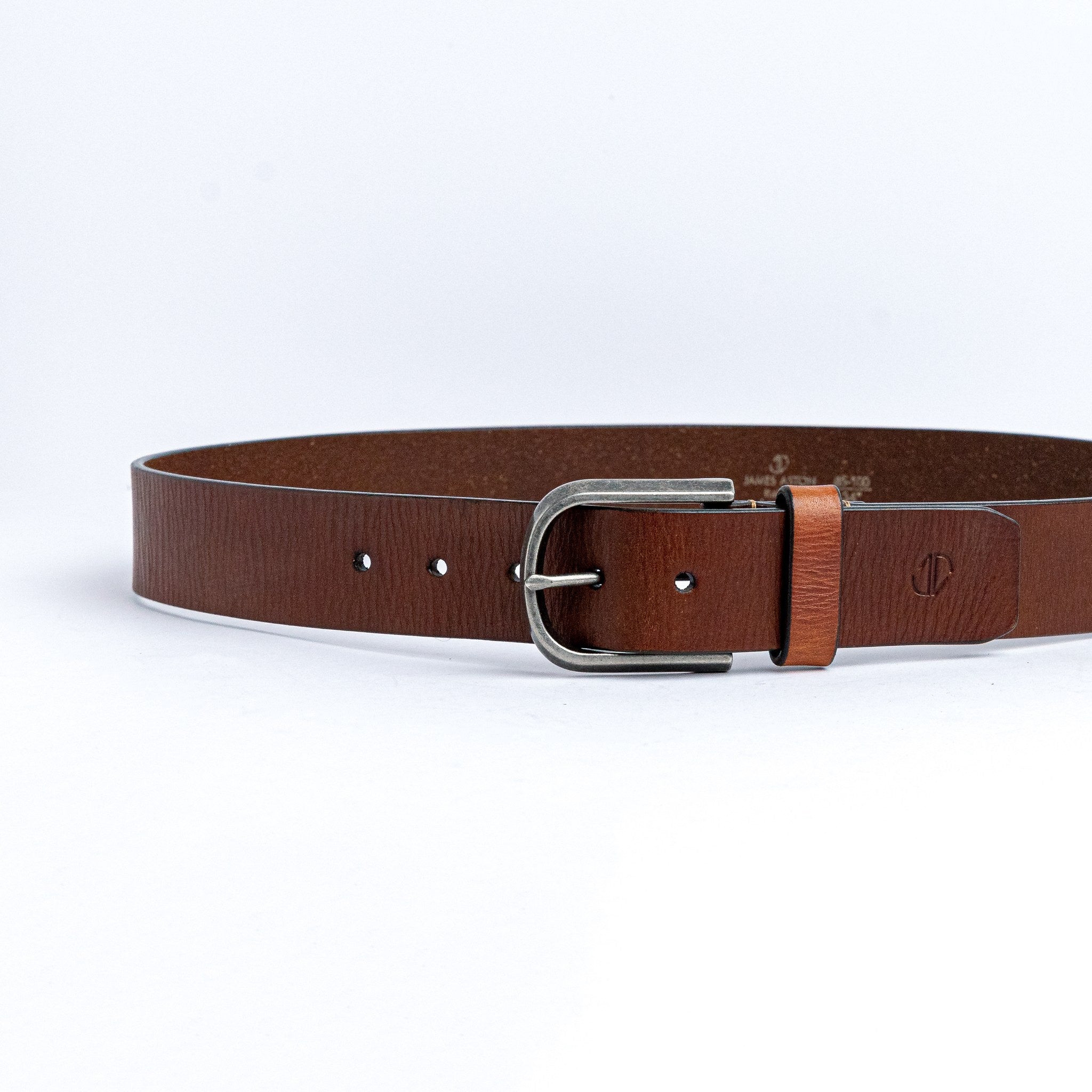 The Pedro belt in cognac milled leather shown at full length, with silver finish buckle