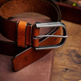 Close view of the silver finish buckle and hand-sewn buckle points on the Pedro belt in cognac