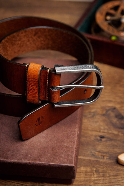 Close view of the silver finish buckle and hand-sewn buckle points on the Pedro belt in cognac