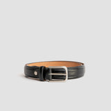 The Ramon black dress belt composed against a woven basket and wood, by James Aston