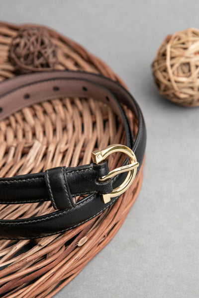 The natural Vachetta leather of the Vittoria dress belt in black.