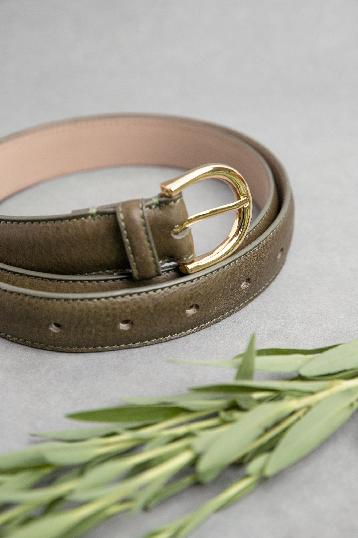 The natural Vachetta leather of the Viviana dress belt in olive.